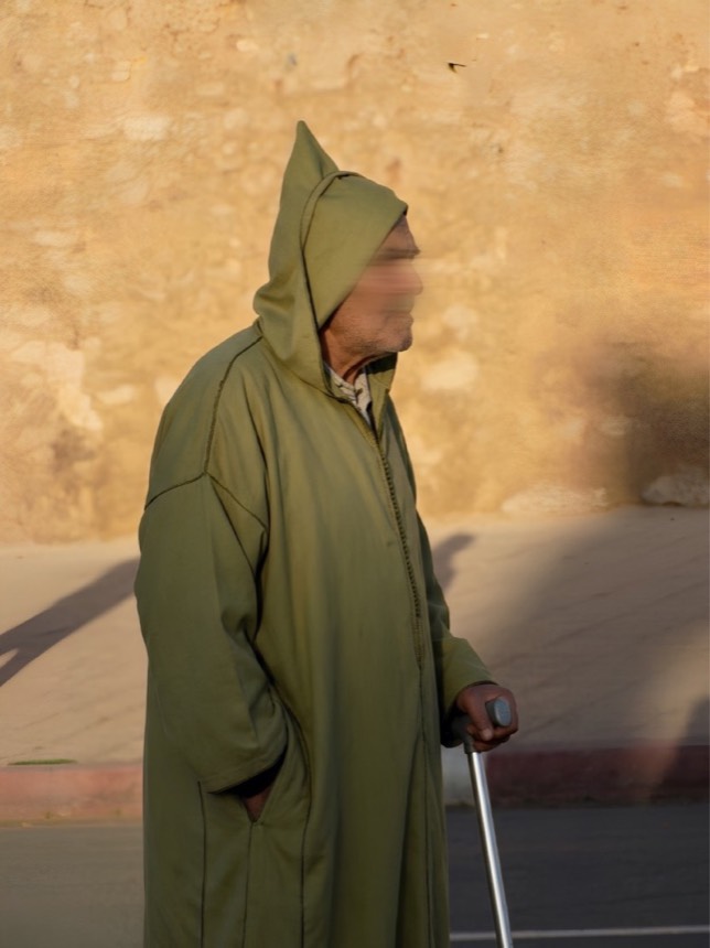 Un homme âgé en djellaba verte, de profil